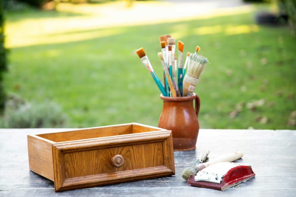 Painting a vintage furniture outdoors, an eco-friendly re-use business.